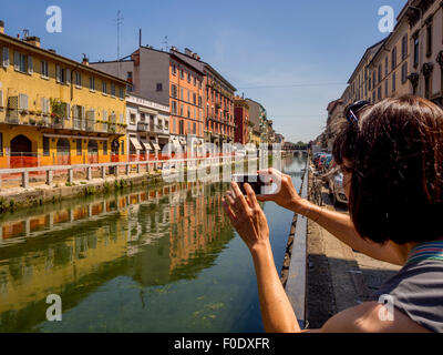 Tourist photographing côté canal bâtiments dans la région de Naviglio Milan, Italie Banque D'Images