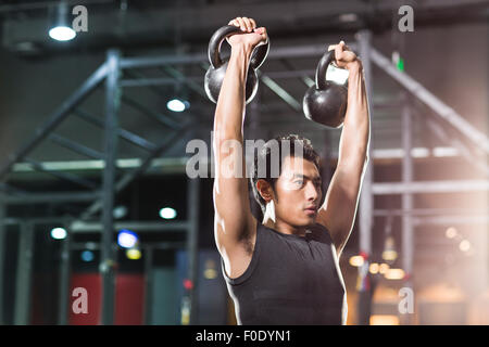 Jeune homme avec formation en sport crossfit kettlebells Banque D'Images