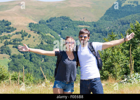 Couple heureux en randonnée entouré de montagnes. Des couples randonnées Banque D'Images