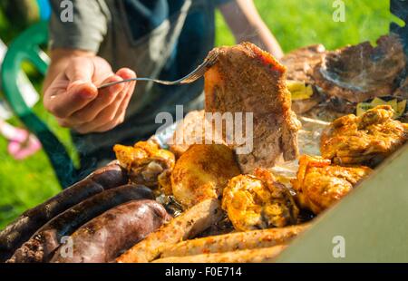 Temps de barbecue. Les temps de cuisson. De diverses viandes et saucisses sur le gril chaud. Banque D'Images