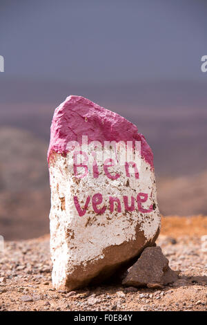 Pierre pierre rose et blanc avec word 'bienvenue' écrit en français dans les montagnes de l'Atlas, sur la route de Marrakech. Maroc Banque D'Images