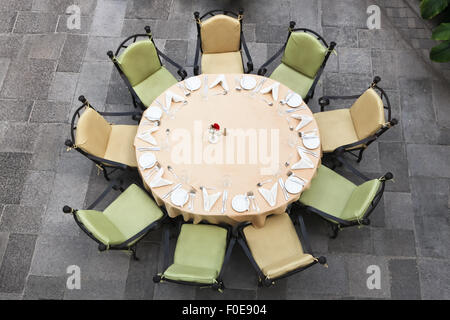 En regardant une grande table ronde pour 9 personnes sur une brique d'un patio. Banque D'Images