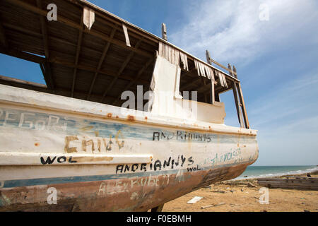 Vieille épave debout sur la plage avec la mer en arrière-plan avec peintures décolorées contre un ciel bleu. L'île de Margarita. Banque D'Images