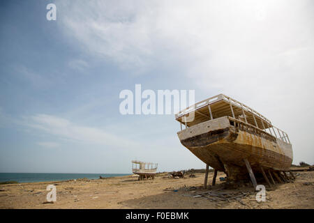 Vieille épave debout sur la plage avec la mer en arrière-plan avec peintures décolorées contre un ciel bleu. L'île de Margarita Banque D'Images