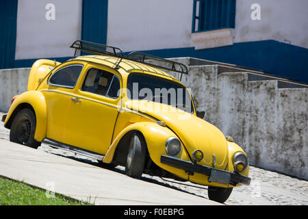 Horloge jaune coccinelle Volkswagen stationné dans la rue d'une ville coloniale dans l'état de Mérida, Venezuela 2015. Banque D'Images