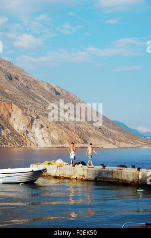 Deux garçons sur une jetée dans le village balnéaire de Loutro dans le sud-ouest de la Crète, Grèce Banque D'Images