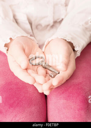 Little girl holding old vintage clé dans ses mains Banque D'Images