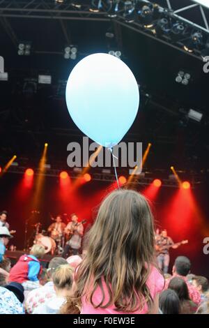 Fille avec un ballon bleu assis sur les épaules à un festival de musique Banque D'Images