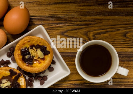 Tarte aux oeufs traditionnels portugais d'être mangé avec du café. Banque D'Images