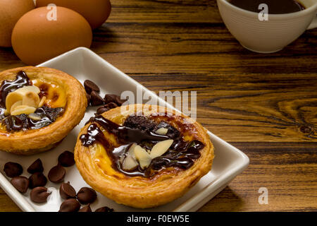 Tarte aux oeufs traditionnels portugais d'être mangé avec du café. Banque D'Images