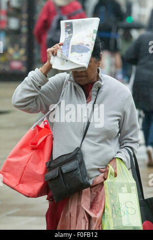 Wimbledon, Londres, Royaume-Uni. 14 août, 2015. Les piétons les banlieusards rentrant du travail à l'abri de la pluie dans le centre-ville de Wimbledon. Credit : amer ghazzal/Alamy Live News Banque D'Images