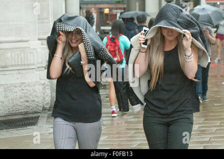 Wimbledon, Londres, Royaume-Uni. 14 août, 2015. Les piétons les banlieusards rentrant du travail à l'abri de la pluie dans le centre-ville de Wimbledon. Credit : amer ghazzal/Alamy Live News Banque D'Images