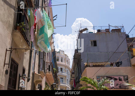 Vue vers le bas Havana street, blanchisserie pendaison en premier plan du vieux bâtiment en ruine. Banque D'Images