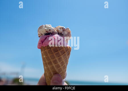 Cornet de crème glacée contre un ciel d'été bleu clair lumineux Banque D'Images