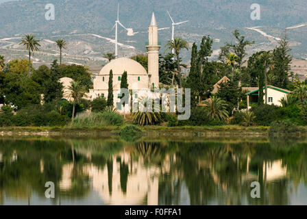 Sultan Tekke mosquée près de Larnaca à Chypre vue de l'ensemble du lever du soleil sur le lac de sel. Avec la réflexion sur l'eau Banque D'Images