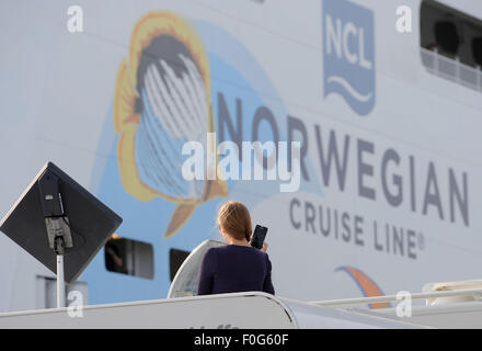 Papenburg, Allemagne. Août 15, 2015. Une femme est assise sur le toit de son camping van alors qu'elle voit l'appareillage du nouveau navire de croisière Norwegian 'Escape' à la chantier Meyer de Papenburg, Allemagne, 15 août 2015. Les 325,9 mètres de long navire avec une capacité de 4 200 et d'un tonnage brut de 164 600 est programmé pour être livré à la mi-septembre. Photo : INGO WAGNER/dpa/Alamy Live News Banque D'Images