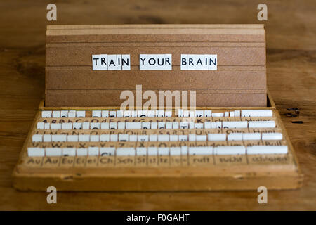 Les mots 'train your brain' sur une vieille lettre de l'école fort Banque D'Images