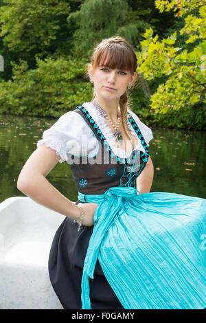 Jeune femme en dirndl sur un bateau à rames Banque D'Images