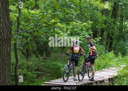 Deux mecs sur leurs vélos de montagne retour à l'un d'entre eux et de donner un coup de pouce à Cannock Chase visitor centre Wolverhampton UK Banque D'Images