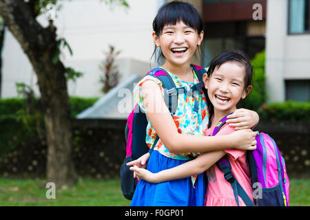 Heureux les petites filles avec leurs camarades s'amuser à l'école Banque D'Images