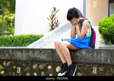 Le stress girl sitting et de penser de l'école Banque D'Images