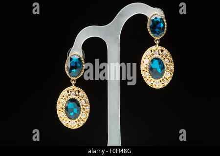 Boucles d'oreilles avec des pierres bleues sur le noir Banque D'Images