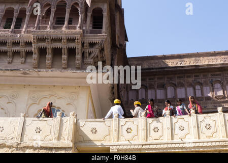 Jodhpur, Inde. Mehrangarh Fort ; les visiteurs indiens dans des robe colorée sur un balcon Banque D'Images