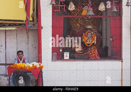 Marchande de fleurs à un sanctuaire hindou à Varanasi, en Inde, pour les fervents d'offrir comme tributs floraux pour leur dieu Banque D'Images