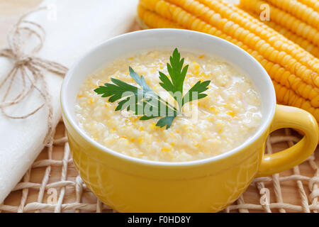 Soupe de maïs brésilien canjiquinha dans bol jaune avec le maïs frais. Selective focus Banque D'Images