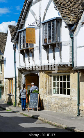 Deux femmes menu lecture, à l'extérieur du restaurant, signe de l'ange, dans le village de Lacock, Wiltshire, Angleterre, Royaume-Uni Banque D'Images