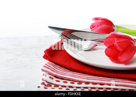 Assiette, couteau et fourchette avec tulipes rouges sur des serviettes Banque D'Images