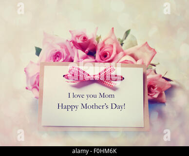 Carte de vœux pour la Fête des mères à la main avec des roses rose Banque D'Images