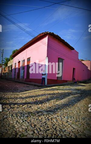 Maison Rose et rue pavée - jeune mec sur un coin de rue à Trinidad, Cuba Banque D'Images