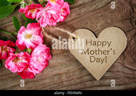Carte de fête des mères en forme de coeur avec des roses sur fond de bois Banque D'Images
