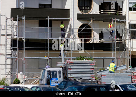 Les travailleurs de la construction l'installation d'un échafaudage sur un bâtiment Banque D'Images