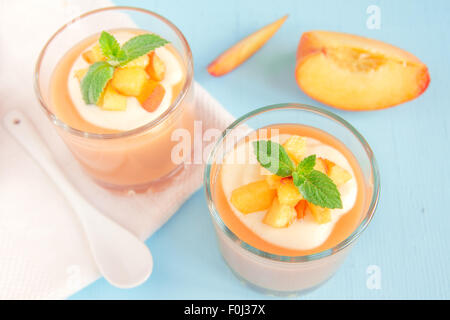 Smoothie pêche dessert (mousse) avec du yaourt et de la menthe en partie verres Banque D'Images