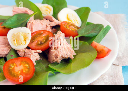 Salade de légumes colorés frais aux épinards, thon, tomates et oeufs de caille Banque D'Images