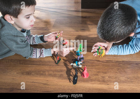 Enfants jouant avec des petits jouets vintage sur le plancher Banque D'Images