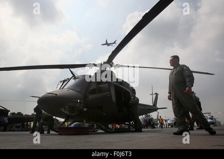 Pasay City, Philippines. Août 17, 2015. Un membre de la Philippine Air Force (PAF) se penche sur un nouveau EP-412Bell Hélicoptère durant une cérémonie à roulement Villamor Air Base à Pasay City, Philippines, le 17 août, 2015. Le PAF a acquis huit hélicoptères Bell-412EP du Canada et deux hélicoptères AW-109E qui peut réaliser l'appui aérien rapproché et de reconnaissance de l'air ainsi que les opérations de levage de l'air dans différentes parties du pays. © Rouelle Umali/Xinhua/Alamy Live News Banque D'Images