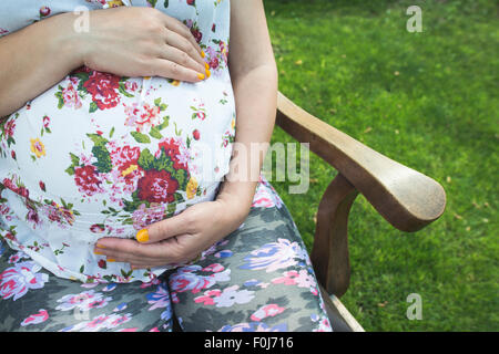 Les femmes enceintes image en attente d'utérus. La lumière du jour dans le jardin Banque D'Images