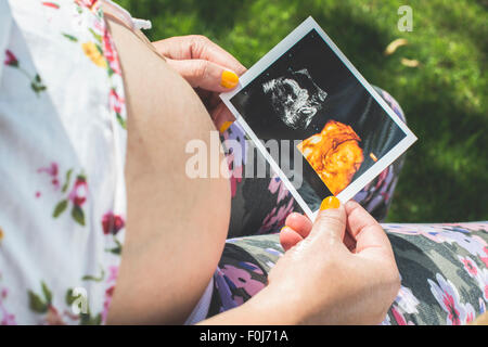 Les femmes enceintes image en attente d'utérus. La lumière du jour dans le jardin Banque D'Images