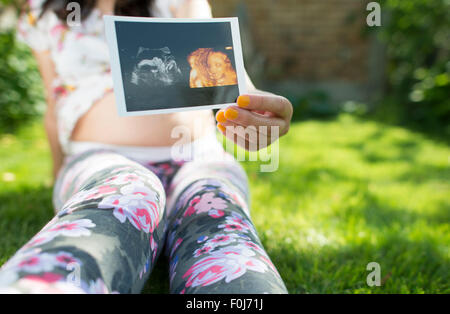 Les femmes enceintes image en attente d'utérus. La lumière du jour dans le jardin Banque D'Images