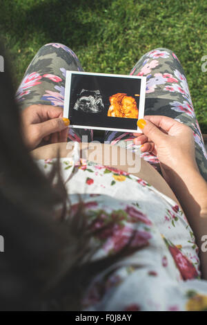 Les femmes enceintes image en attente d'utérus. La lumière du jour dans le jardin Banque D'Images