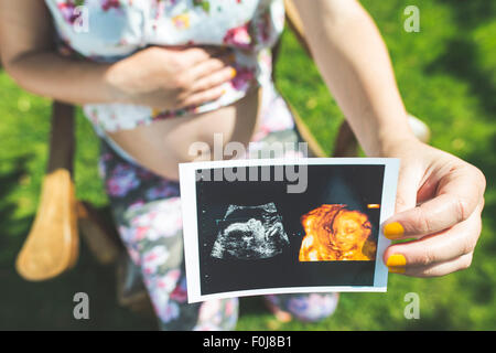 Les femmes enceintes image en attente d'utérus. La lumière du jour dans le jardin Banque D'Images