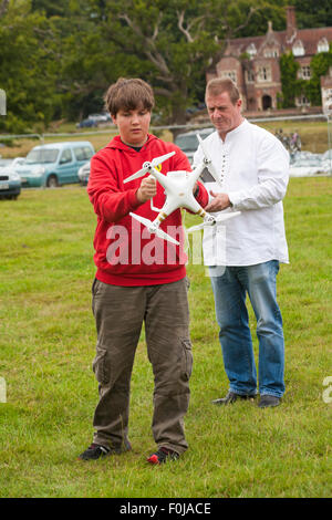 Jeune homme exploitant le drone DJI Phantom avec caméra attachée au New Forest Fairy Festival, Burley, Hampshire, Royaume-Uni en août Banque D'Images