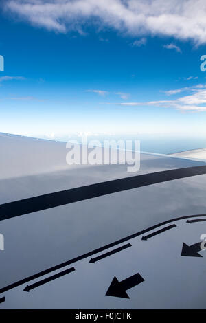 Voir l'aile d'avion à réaction de cristal avec ciel bleu en arrière-plan et la sûreté et la sécurité marqueurs comme des flèches de droite à gauche. Banque D'Images