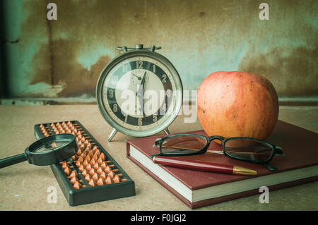 La papeterie et une pomme sur le bureau. Banque D'Images