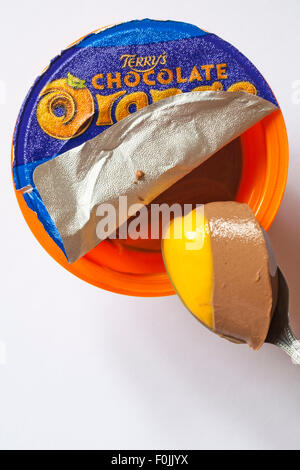 Terry's Chocolate Pots Orange de joie avec couvercle décollée pour afficher le contenu du panier et d'une cuillerée de supprimé prêt à manger situé sur fond blanc Banque D'Images