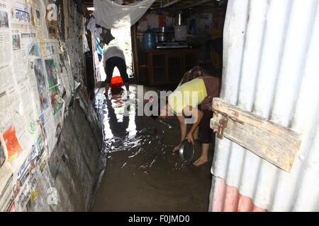 Katmandou, Népal. Août 17, 2015. Une famille efface l'eau dans un hangar après l'inondation découlant de la rivière Bagmati gonflée d'un bidonville à Gairigaon à Katmandou, Népal, 17 août 2015. Près de 200 familles vivant dans le bidonville ont été touchées par la crue en raison de fortes pluies continues. Credit : Sunil Sharma/Xinhua/Alamy Live News Banque D'Images