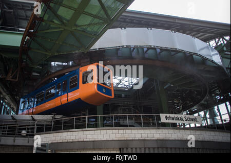 Wuppertal, Allemagne. Août 13, 2015. Une suspension train passe sa station terminale à Wuppertal, Allemagne, 13 août 2015. L'entreprise de services publics de Wuppertal WSW offrira trois voitures de sa position bien connue pour les chemins de fer, avec un autre 21 à partir des années 1970 pour être vendu pour 5 000 euros l'année prochaine lorsque la quatrième génération de la ligne de chemin de fer devrait être en opération. Photo : Maja Hitij/dpa/Alamy Live News Banque D'Images